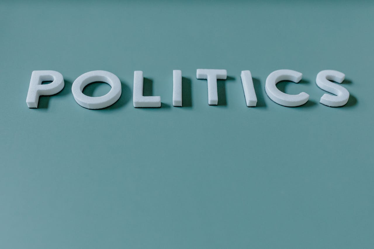 Close-up image of the word Politics against a teal green background, highlighting political themes.